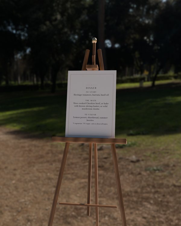 Dinner board · The gilt line, photographed on an easel (the easel is scenery, never sold)