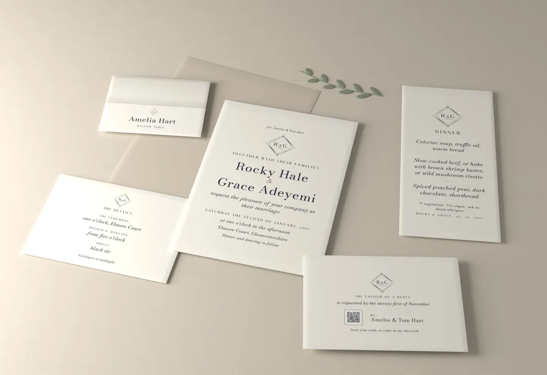 Navy monogram wedding stationery suite, photographed: invitation, reply card, details card, place card and menu